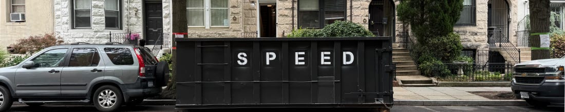 一个停在住宅街道上的黑色垃圾箱,上面漆着 SPEED 字样,后面有一辆车