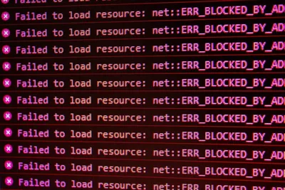 题图:一个终端窗口里刷满了红色的 net::ERR_BLOCKED_BY_AD… 报错,像是部署脚本连续失败时的输出